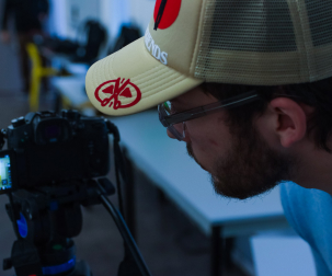 Un étudiant de l'atelier en train de regarder son retour caméra qui filme une scène.